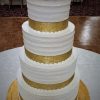 four tiered white and gold cake